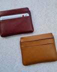 Two card wallets in cherry red and caramel tan with 5 card pockets made from vegan cactus leather with subtle piping detail on edge
