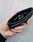 Black 5 card wallet made from vegan cactus leather with subtle piping detail on edge, showing middle pocket