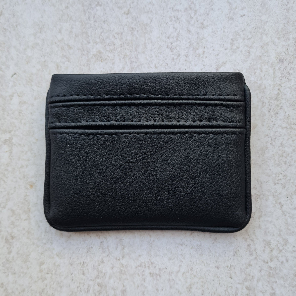 Black pebble textured 5 card wallet made from vegan cactus leather with subtle piping detail on edge